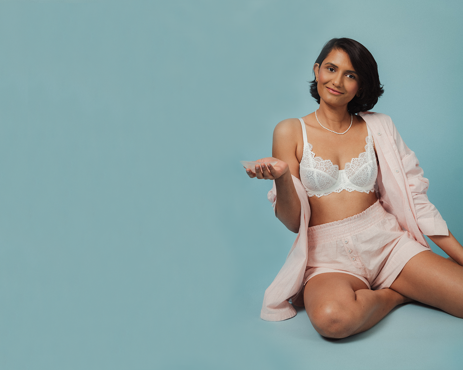 Model holding an evenly bra balancer for breast asymmetry