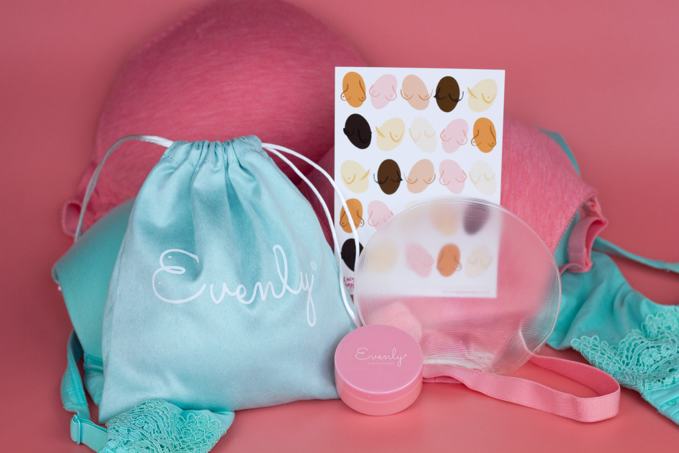 Teal drawstring bag with 'Evenly' branding, pink container, and polka dot card on a pink background for the Best Surgery Free Breast Asymmetry Fix