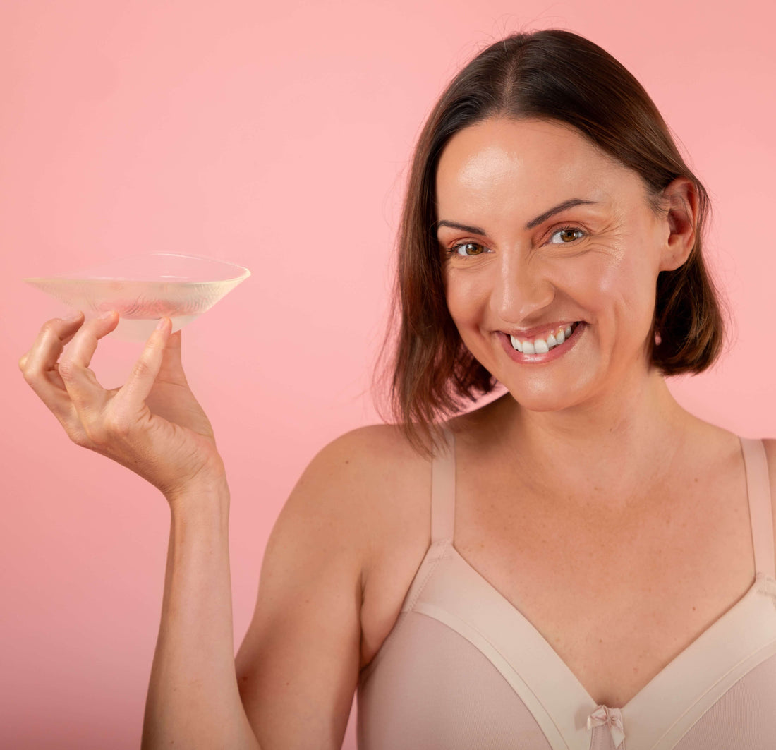 Model holding an Evenly bra filler for lopsided breasts