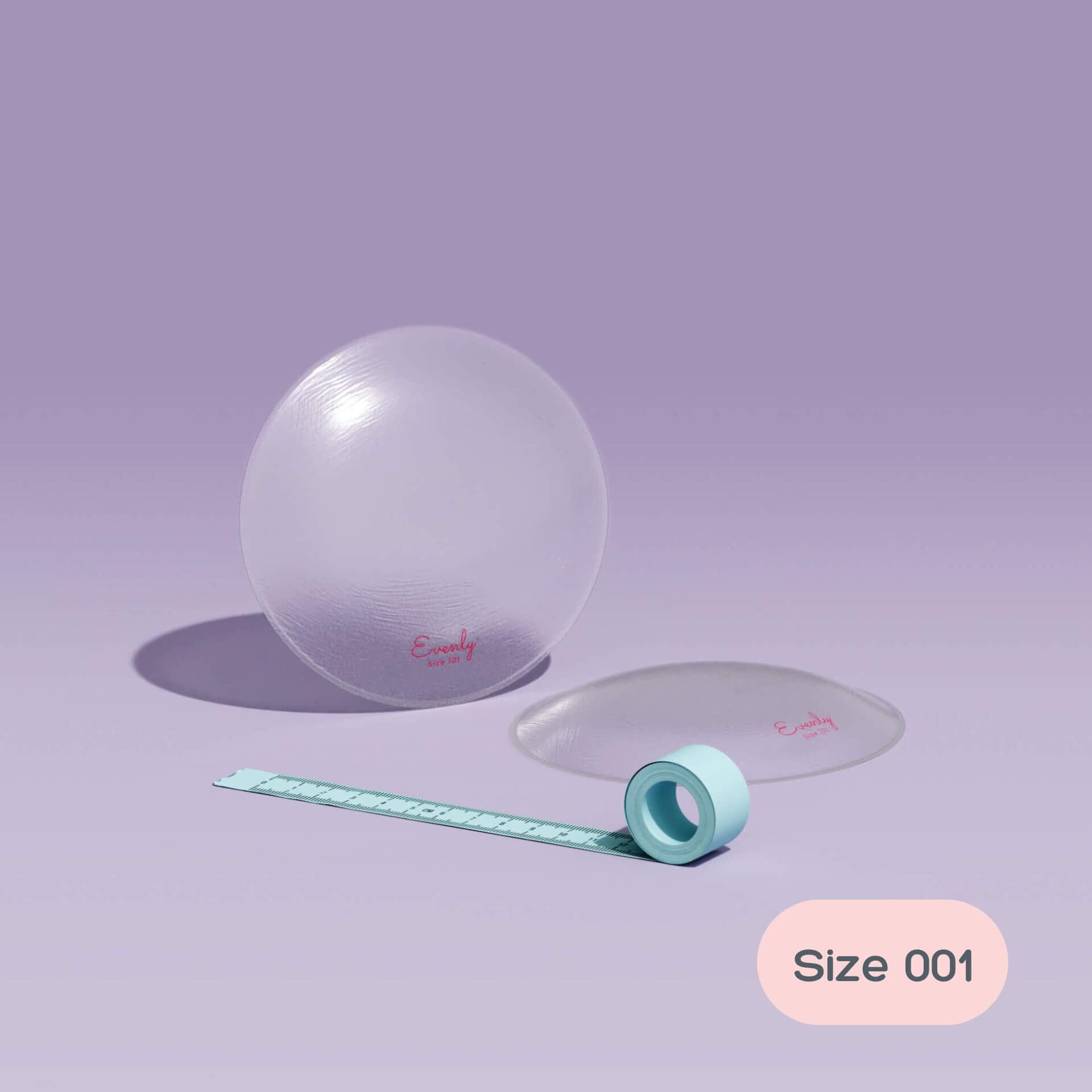 asymmetrical breast inserts and measuring tape on a light purple background