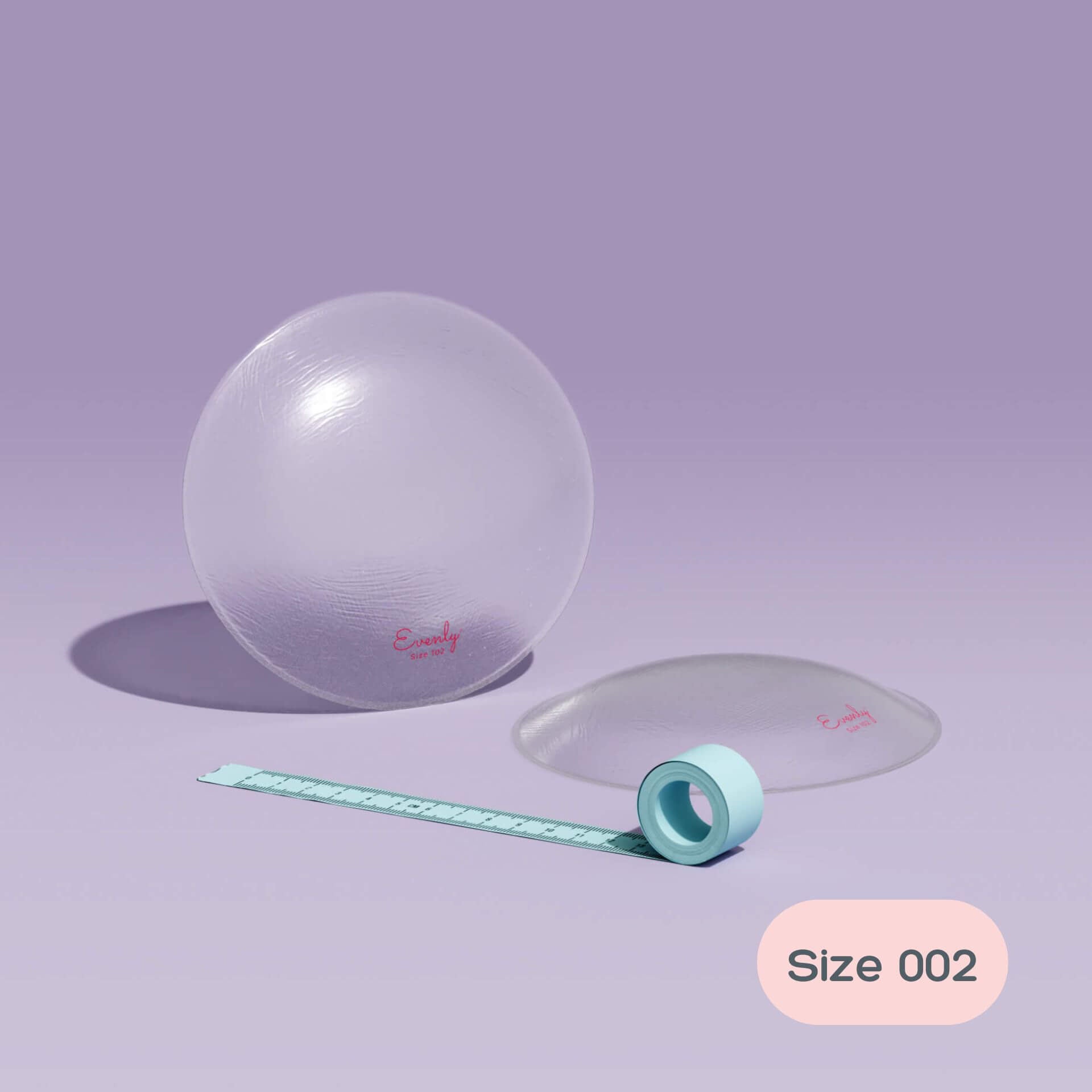 asymmetrical breast inserts and measuring tape on a light purple background