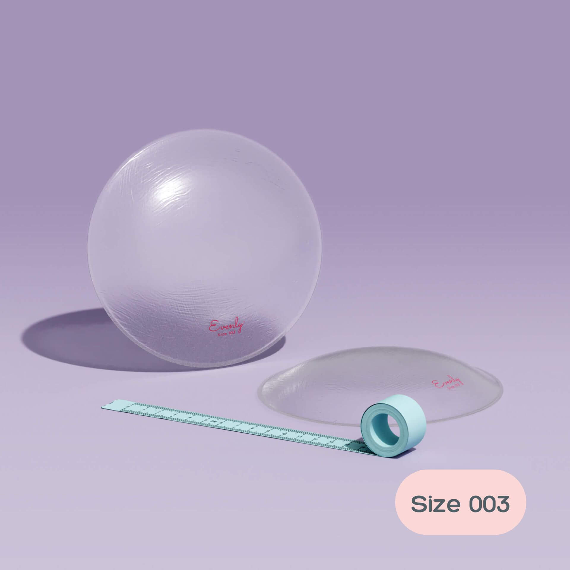 asymmetrical breast inserts and measuring tape on a light purple background